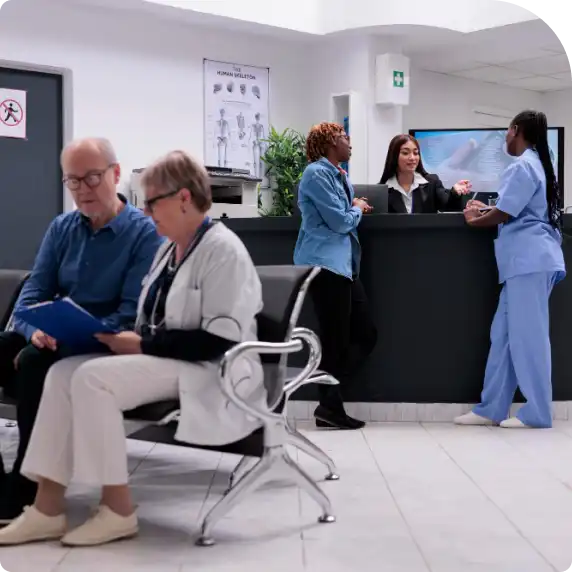People in a hospital reception two medical staff talking to a receptionist
