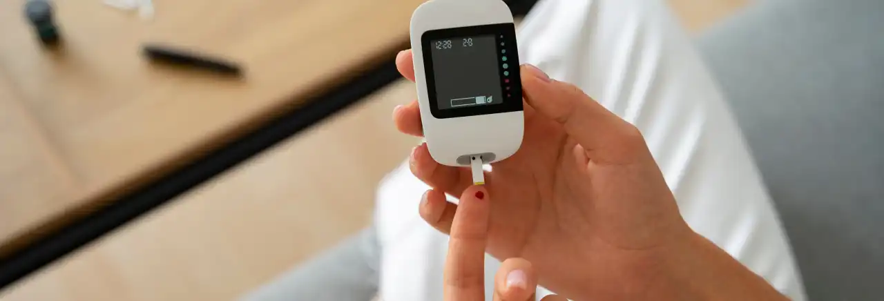 Person using a blood glucose meter to check blood sugar levels.