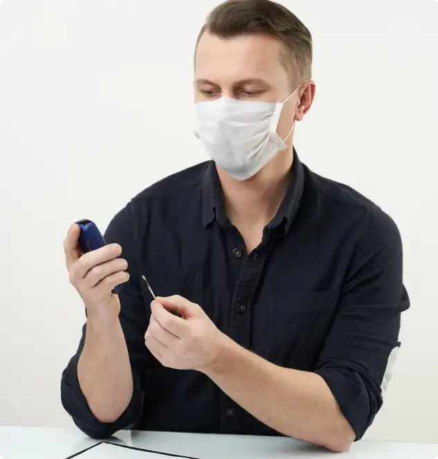 Man wearing a face mask, holding a glucometer, checking his health while staying safe.