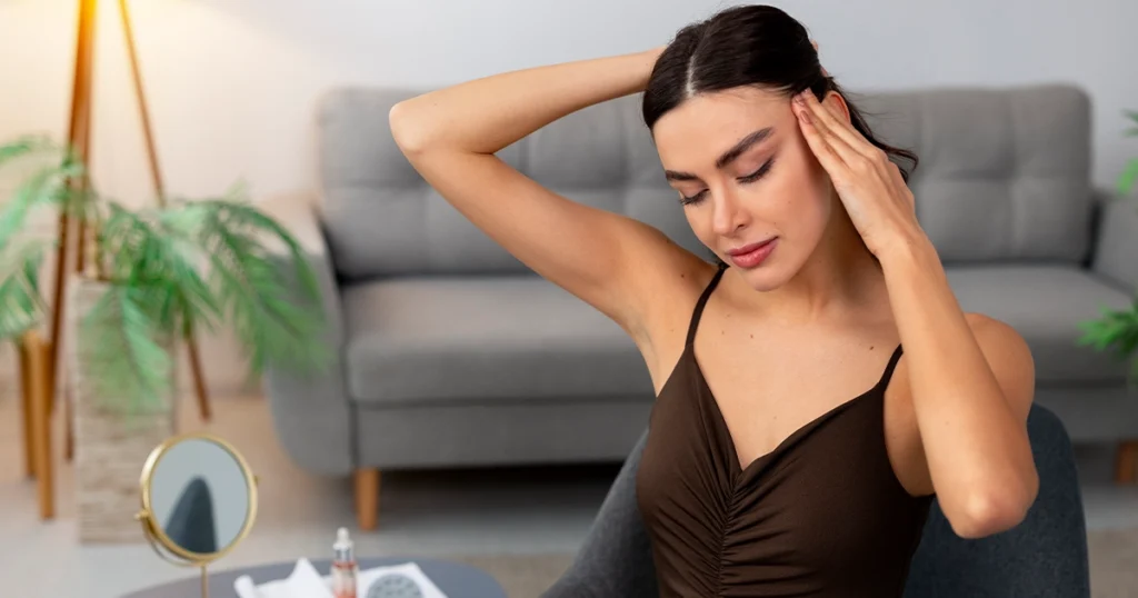 Woman holding her head, experiencing a headache