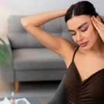 Woman holding her head, experiencing a headache
