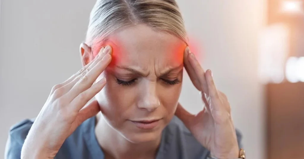 Woman experiencing a cluster headache, holding her temples.