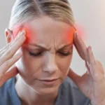 Woman experiencing a cluster headache, holding her temples.