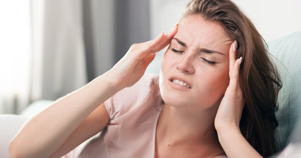 Woman suffering from a headache and massaging her temples