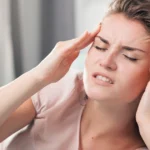Woman suffering from a headache and massaging her temples