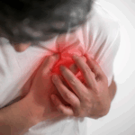 A man clutching his chest, showing signs of burning pain in the chest that may indicate heartburn or a possible medical condition.