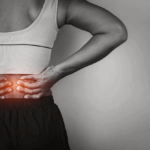 A person holding their lower back in pain, showing discomfort and strain, highlighting symptoms of back injuries.