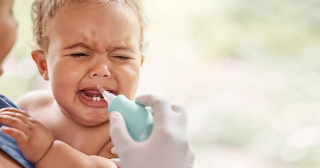 Baby crying while having nasal suction during teething.