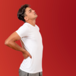 Man holding his middle back in pain on a red background.