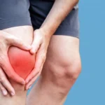 Person gripping their knee with a red glow indicating pain against a blue background.
