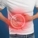 A man in a white t-shirt holding his right side with both hands, featuring a red glowing overlay to indicate abdominal pain.