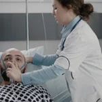 Nurse placing an oxygen mask on a patient in hospital.